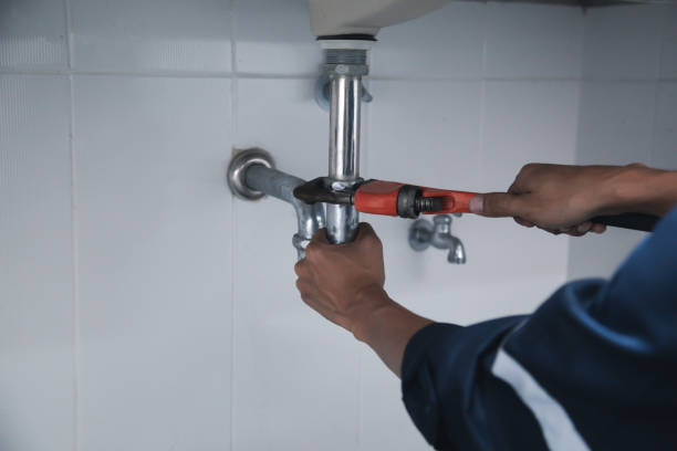 istock Male Plumber Using Wrench To Fix Leaking Sink In Home Bathroom. 1402667888