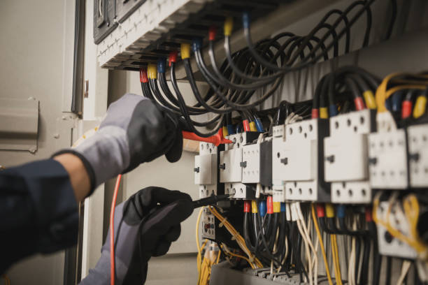 istock Electricity and electrical maintenance service, Engineer hand holding AC multimeter checking electric current voltage at circuit breaker terminal and cable wiring main power distribution board. 1402667919