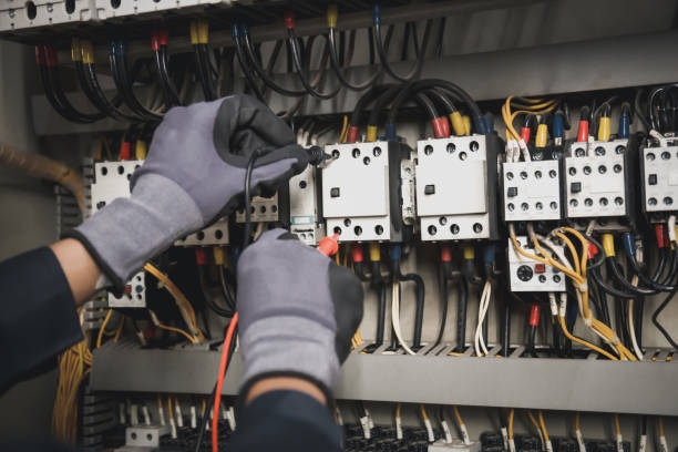 istock Electricity and electrical maintenance service, Engineer hand holding AC multimeter checking electric current voltage at circuit breaker terminal and cable wiring main power distribution board. 1402667924