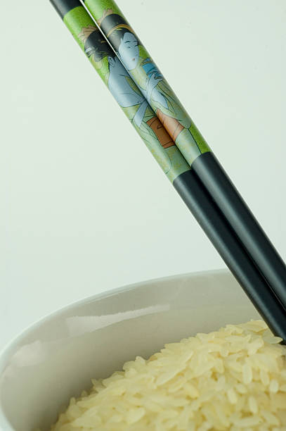 black chopsticks in rice bowl stock photo