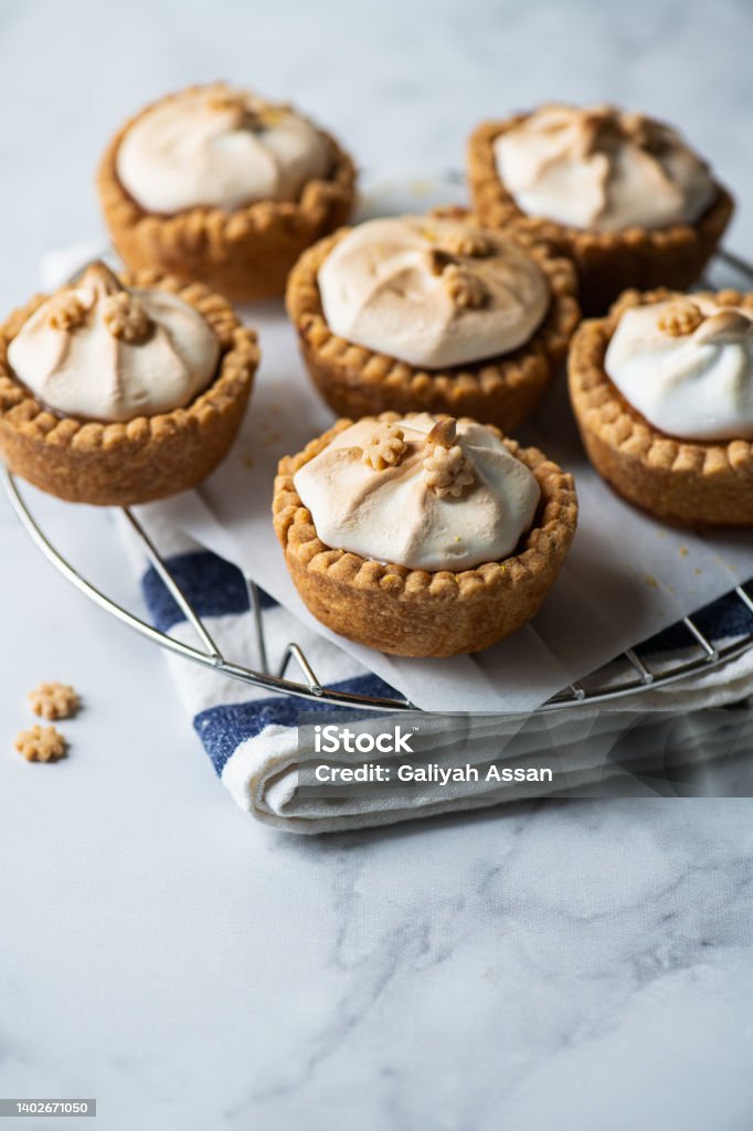 Set of lemon curd tartlets with whipped meringue. Close up. Sweet Pie Stock Photo