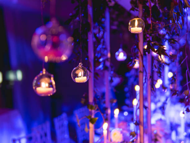 istock Candles in small glass circlular candle holders handled on strings. Beautiful decorations in purple electric light. 1402672585