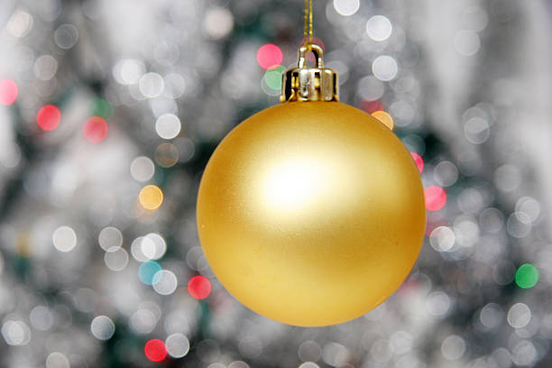 Yellow christmas ball against distant lights stock photo