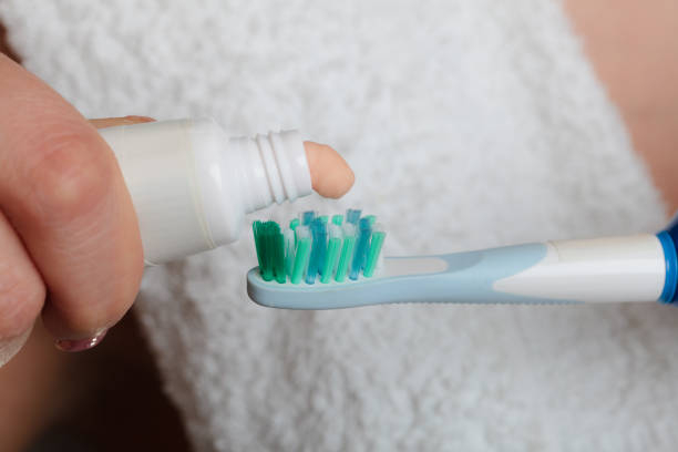 istock Woman hands putting toothpaste on toothbrush 1402673189