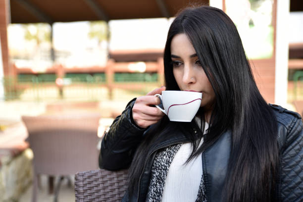 istock thoughtful young woman drinking coffee alone 1402674527