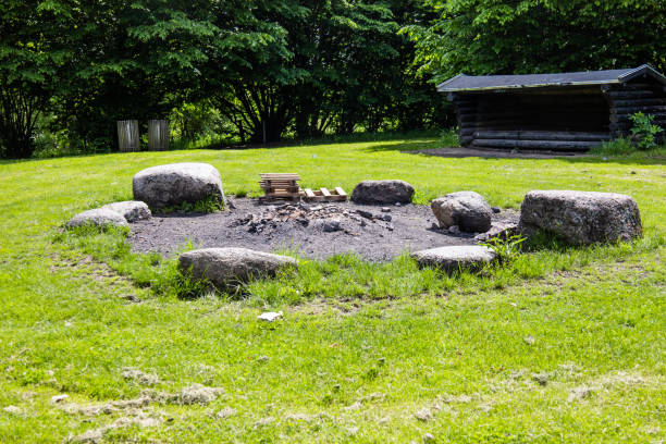 A picnic and campfire area and a small hut in the background.