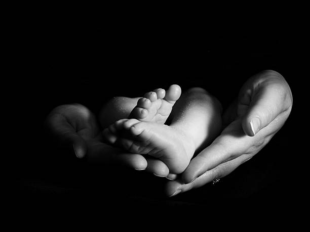 istock Mother's hands holding baby's feet 140268125