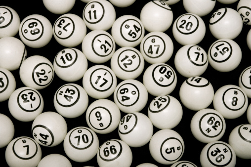 Bingo ping pong balls with numbers on black background.