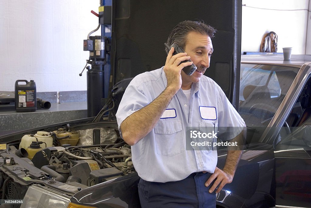 mechanic 3 a mechanic is on the phone giving a customer some information Mechanic Stock Photo