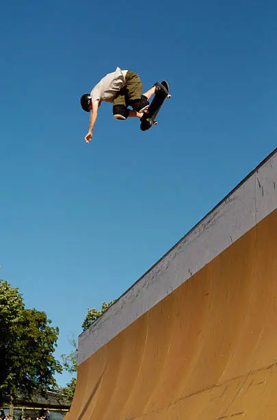 Skateboarder performing a backside Air in the half pipe.