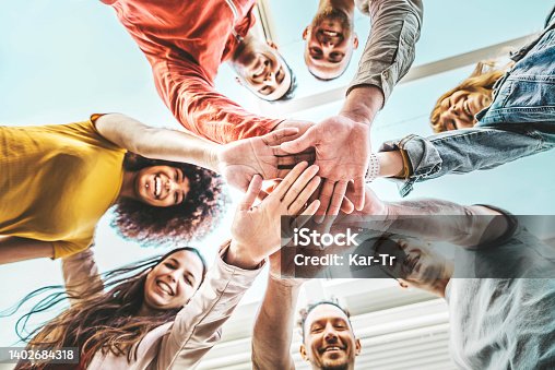 istock Group of young people stacking hands together outdoor - Community of multiracial international people supporting each other - Union, support and human resources concept 1402684318