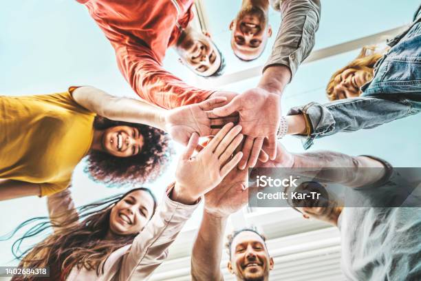 Group Of Young People Stacking Hands Together Outdoor Community Of Multiracial International People Supporting Each Other Union Support And Human Resources Concept Stock Photo - Download Image Now