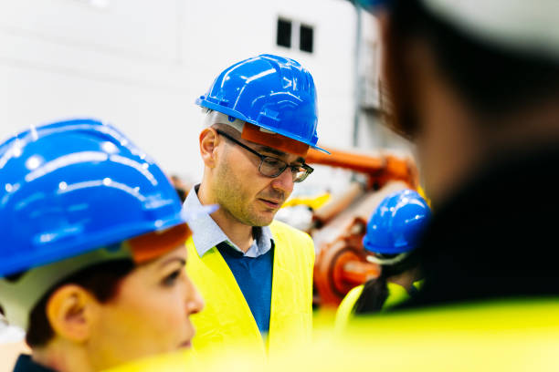 istock group of engineering workers in robotics factory discussing - focus on caucasian man - 1402686435