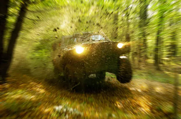 Photo of Off-road vehicle catches air in a heavily wooded area