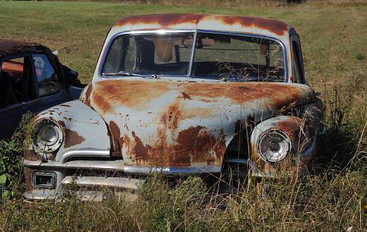 Erick, OK, USA, Oct. 11, 2019: A rusting old car sits abandoned in a field along historic Route 66 near Erick, Oklahoma.