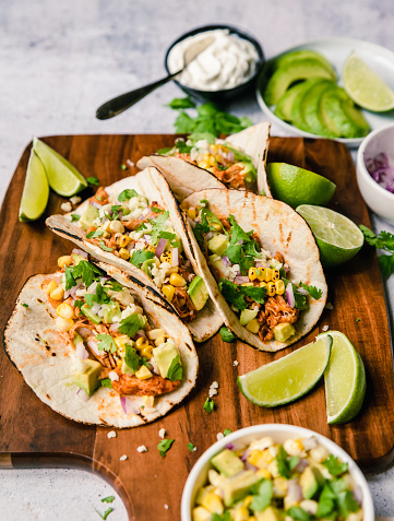 High angle of soft tacos with chicken, corn, avocado and lime. in Kingston, Ontario, Canada