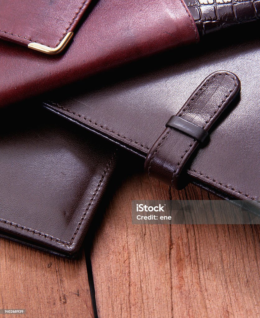 A pile of leather cases on a wooden table leather wallets still life Accessibility Stock Photo