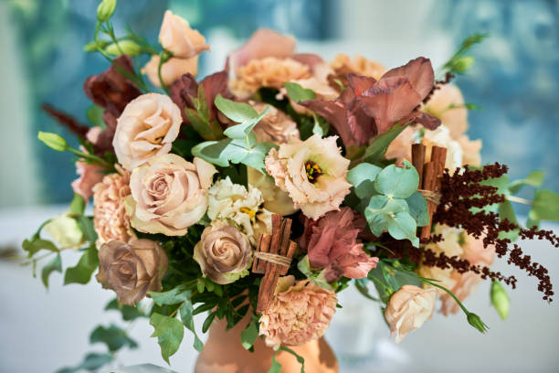 Close up of bridal bouquet of roses and greenery in vase on table outdoors, copy space. Wedding concept stock photo
