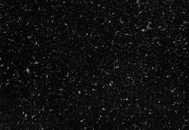 dark black real terrazzo cement wall with shallow groove pattern. close up view of black concrete wall texture with white grain use as background. wall surface consists of marble and granite element.