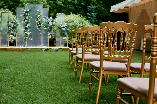 istock Place for wedding ceremony in garden outdoors, copy space. Wedding arch decorated with flowers and chairs on each side of archway. Wedding setting 1402690821