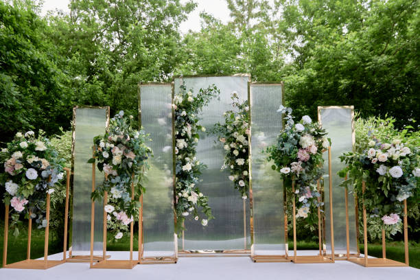 Place for wedding ceremony in garden outdoors, copy space. Wedding arch decorated with flowers. Wedding setting stock photo