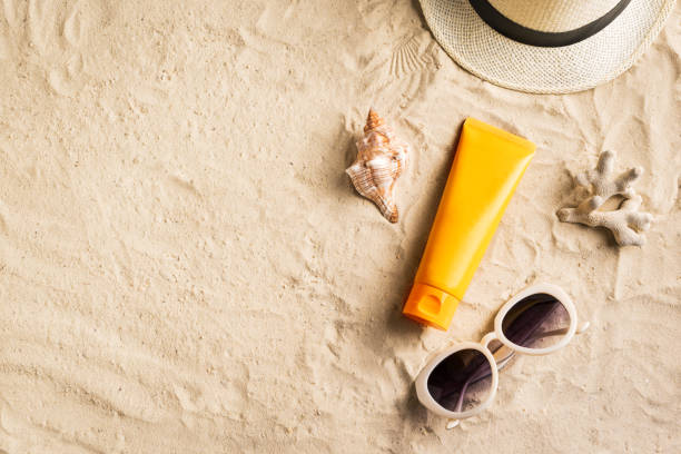 Sunscreen sunblock lotion on sandy beach Sunscreen lotion on sandy beach as background, top view, copy space. Summer vacation and skin care concept, spf uv-protect cosmetic products. suntan lotion stock pictures, royalty-free photos & images