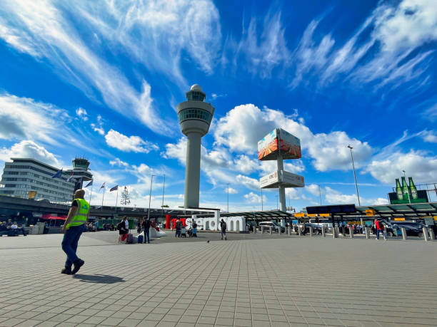 passengers outside airport terminal with control tower amsterdam stock photo