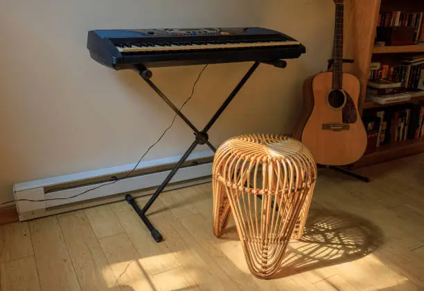 Musical,instruments, an electric piano keyboard, and guitar, in a living room of a country home in Pennsylvania.