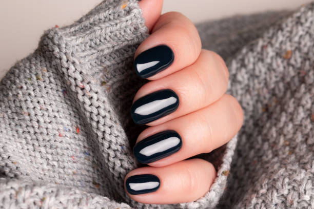 istock Female hand with black nails 1402693228