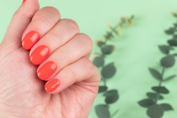 istock Female hand with coral, red orange nails 1402693236
