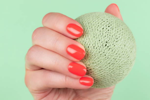 istock Female hand with coral, red orange nails 1402693240