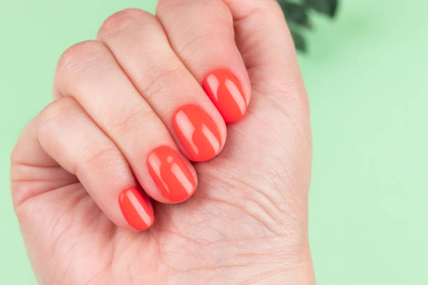 istock Female hand with coral, red orange nails 1402693275