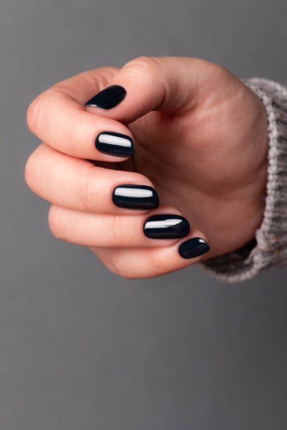 istock Female hand with black nails 1402693279