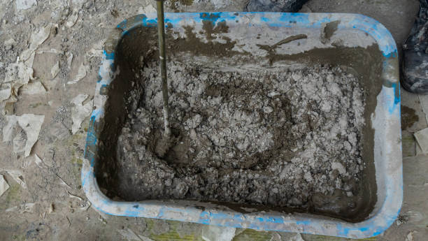istock Mixing tile adhesive or cement with a power drill for repair works on construction site. Waiting to be mixed with cement. 1402694173