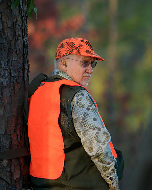 Deer Hunter Leaning Against Tree stock photo