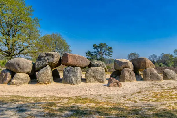 D53 is the second largest hunebed in Holland (D27 is 'the first') and one with a remarkable history.  It counts 9 capstones, all of them resting nicely on their foundations, consisting of 23 sidestones and 2 endstones. There is a complete porch with 4 passage sidestones and 1 capstone. Of the big oval wrench, 10 kerbstones are still there.  Under the supervision of Professor Van Giffen D53 has been the subject of a thorough archaeologic research and not without success. In and under the floor of the burial chamber, researchers found potsherds of 665 pieces of pottery, 3 stone axes, an arrow-point, a bludgeon, and 4 amber beads. Never before so many artifacts had been found in a hunebed.  In 1945 the fate of this marvelous hunebed seemed to be sealed. The German Army that occupied Holland demanded this megalithic monument to be dismantled for the construction of an airfield. The inevitable demolition took place, but the Dutch authorities had taken their precautions: all 50 big and smaller boulders were pushed into a 6 meter deep pit in the ground by a shovel. Immediately after the war the stones were dug up again and in 1949 the restoration started. In 1950 the hunebed showed off again in all its glory as if nothing had happened!  Havelte, Netherlands