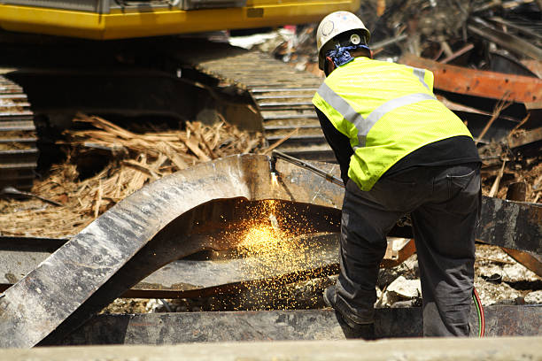 Man cutting steel beam at a demolition site.   - see lightbox for more
