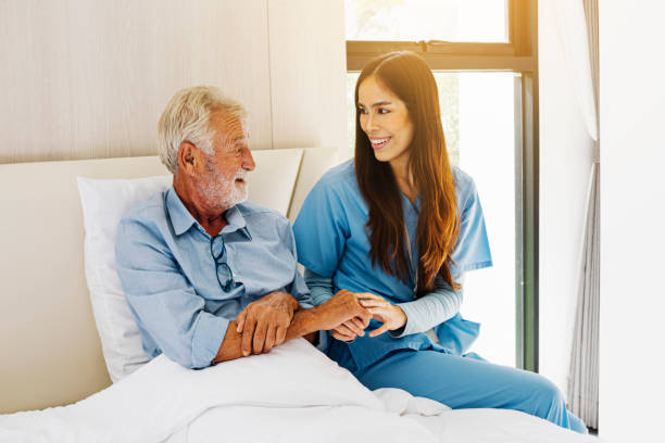 istock Caregiver nurse and old man on bed 1402698817
