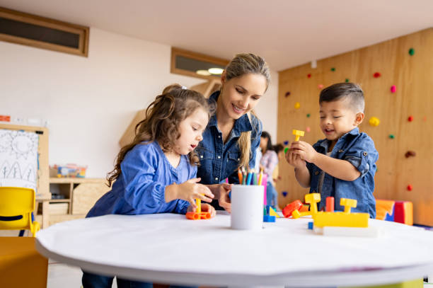 istock Happy teacher playing with children in class 1402700250