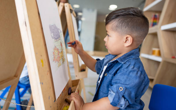 istock Happy boy at the school coloring in art class 1402700271