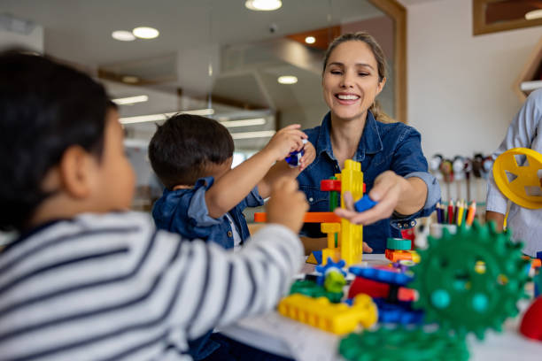 istock Happy teacher playing with her young students in the classroom 1402700272