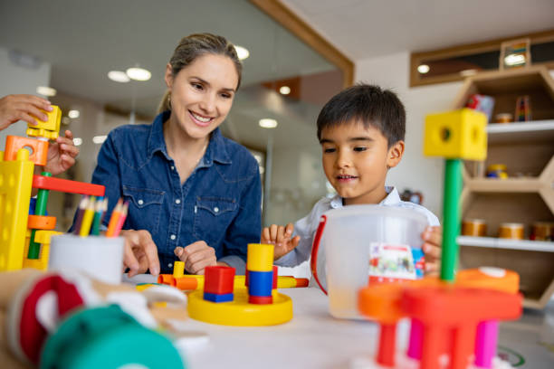 Schoolboy playing with building blocks in the classroom stock photo