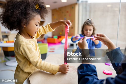 istock Girls playing with slime in class at the school 1402700285