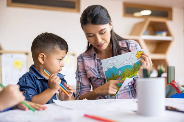 istock Art teacher showing a boy a reference to color his drawing 1402700287