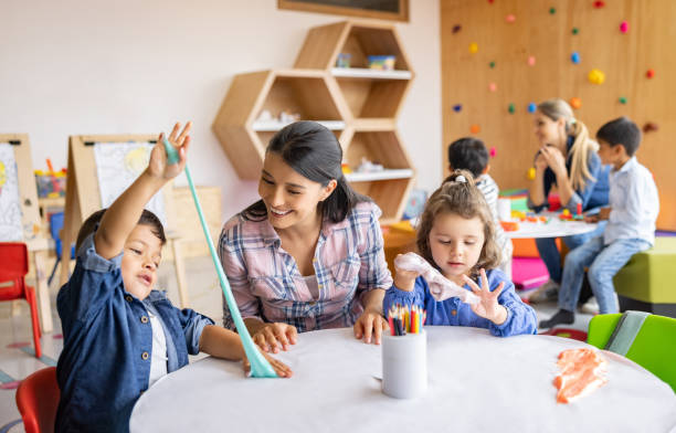 학교에서 점액을 가지고 놀고 선생님을 보여주는 행복한 아이들 - child art and craft latin american and hispanic ethnicity little boys 뉴스 사진 이미지