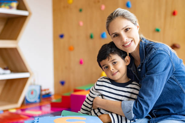 istock Happy teacher hugging a young student at the school 1402700316
