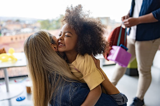 istock Happy schoolgirl hugging her mother while she is picking her up from school 1402700339