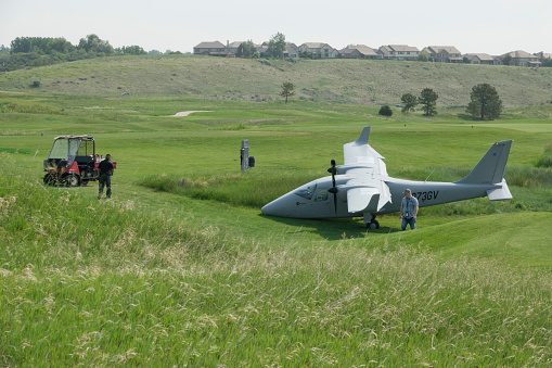 At approximately 7:30 am on June 13, 2022, a twin engine airplane flying eastwards over Bear Creek Lake Park dove steeply over Mount Carbon in Lakewood Colorado, and then banked heavily to the north and successfully crash landed on the nearby 10th fairway of the Fox Hollow Golf Course. The plane broke its nose landing gear near the putting green. FAA investigators, Lakewood Police and Bear Creek Lake Park Rangers arrived at the scene. Photographing from the adjacent, public accessible, Bear Creek Lake Park trail, the photos show investigators inspecting and photographing the plane with nearby golf carts and police as well as homes in the distance.