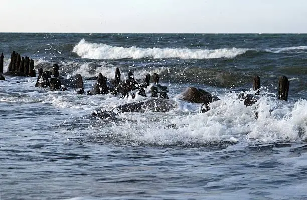 german baltic-sea coast kAhlungsborn on a blustery autumn day on the breakwaters and stons sparking the waves 