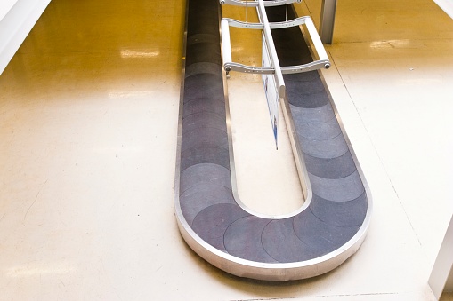 Empty baggage carousel at a German airport. Due to a lack of staff for baggage handling, flight counters are closed, baggage cannot be checked in, passengers cannot fly or can only fly very late.